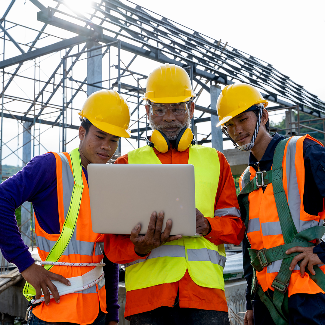 group of construction workers looking at a computer