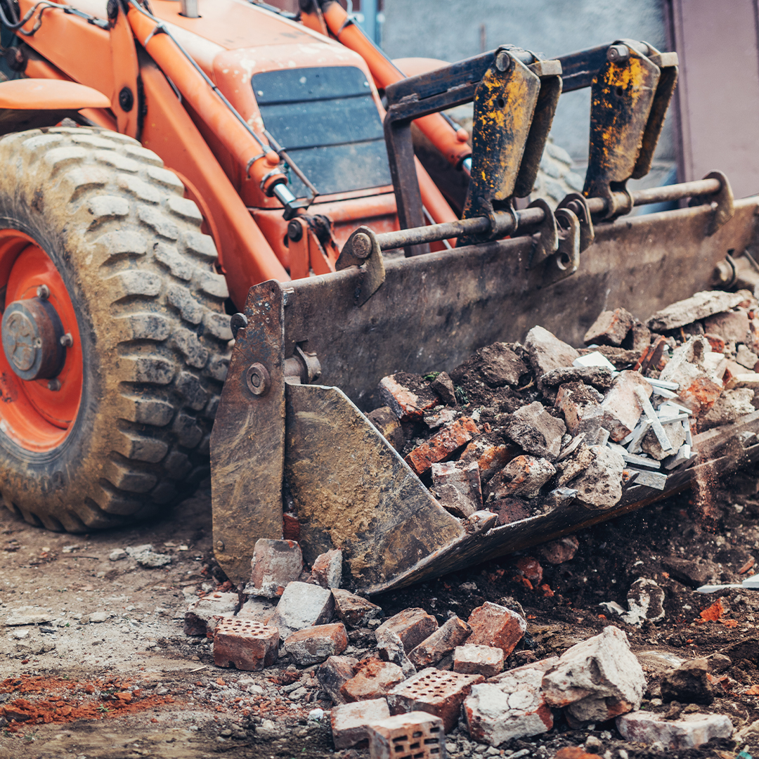 large equipment picking up broken bricks