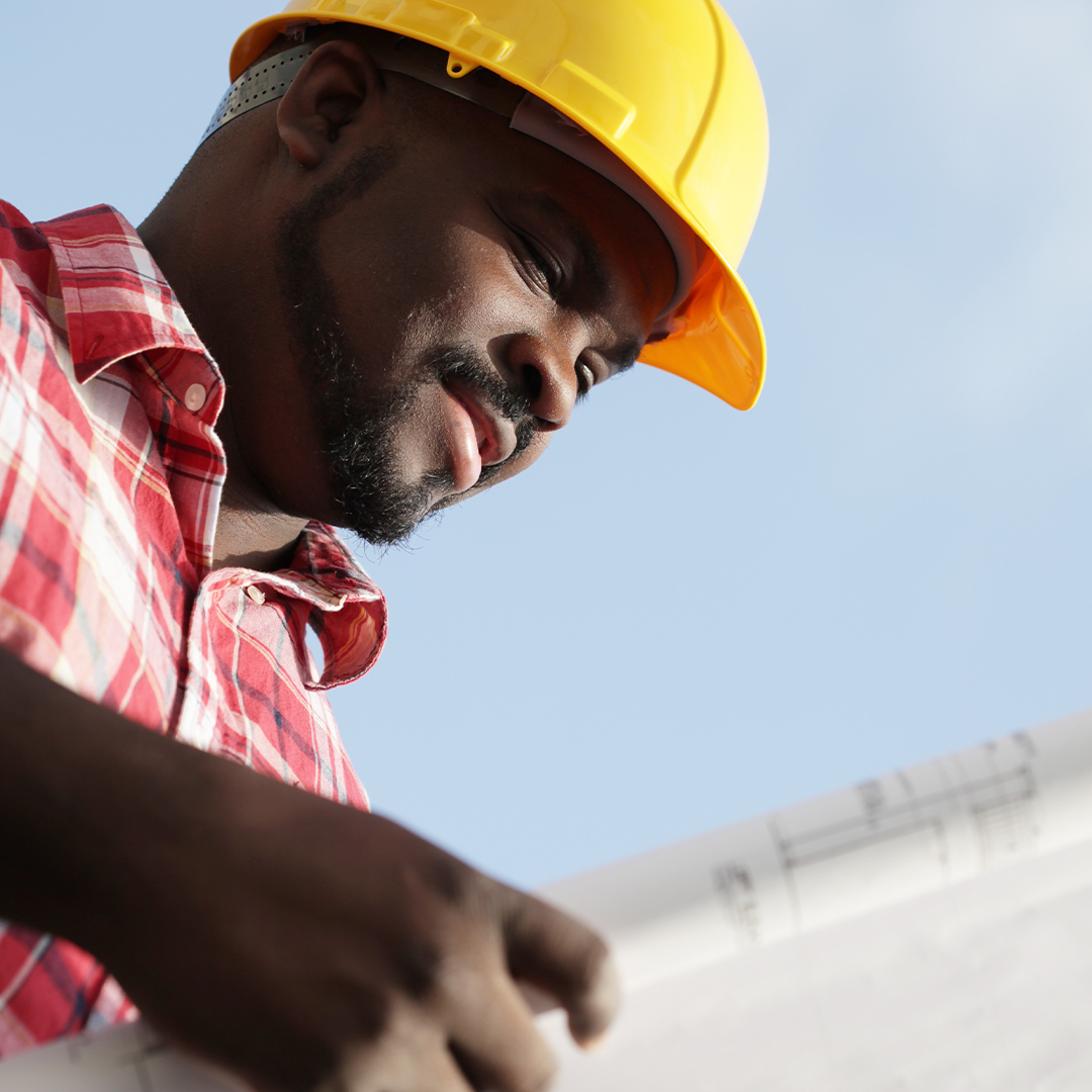 minority man looking over blueprint plans