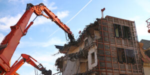 two large bucket machines demoing a building