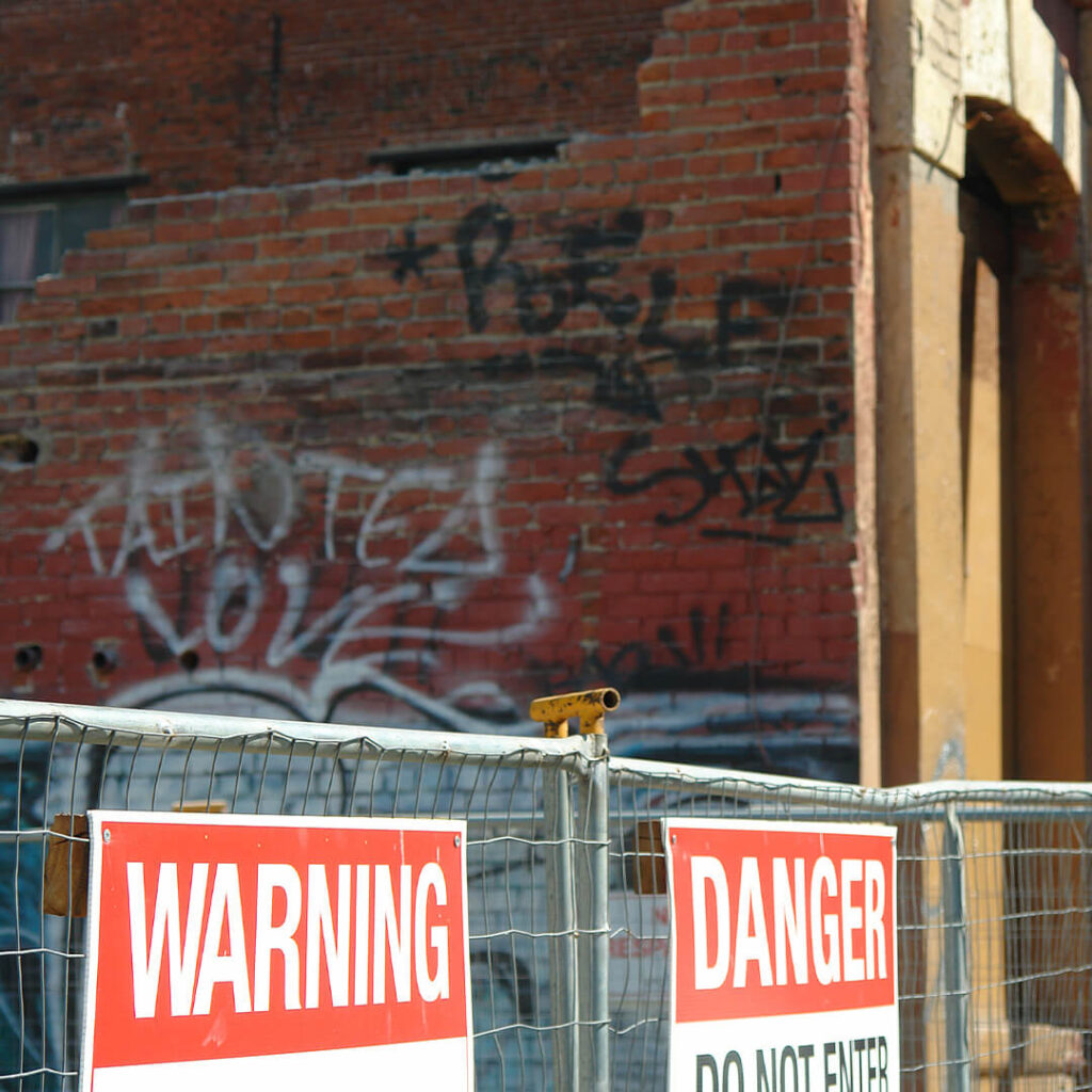 warning and danger signs outside of a brick commercial building